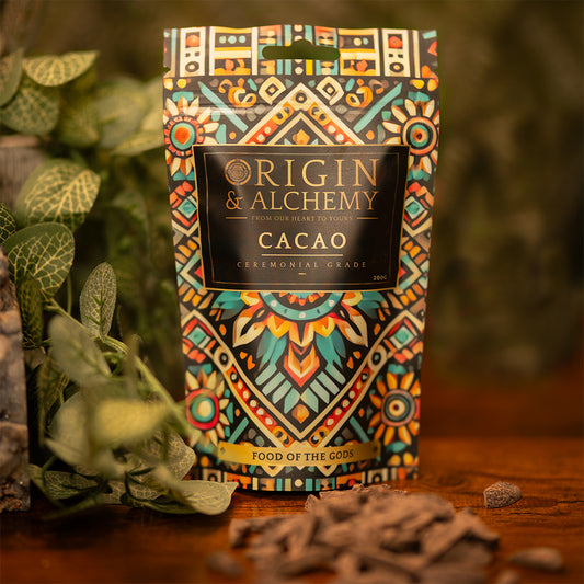 A package of 200g Origin & Alchemy Cacao with a colorful, patterned design, displaying the text 'Food of the Gods' and images of cacao beans and plants in the background.